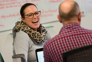 A smiling female associate interacting with a male associate.