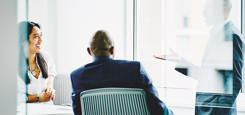 Two men and a woman having a discussion in a conference room