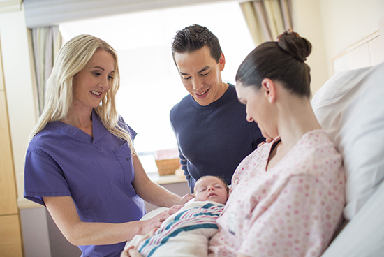 Nurse with the newly born baby and its parents