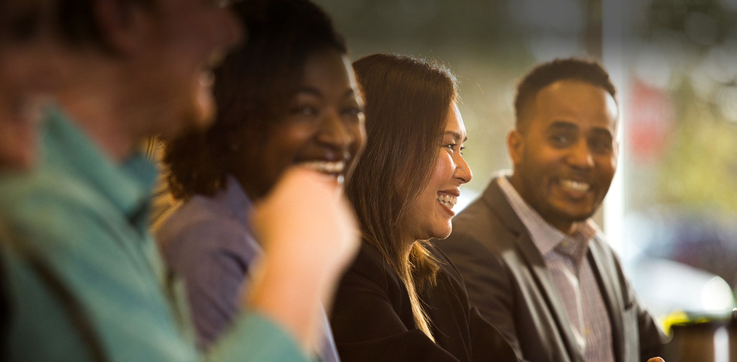 smiling HGV team members seated at a conference table