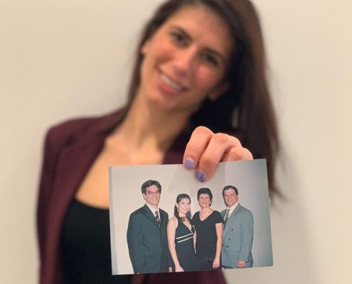 Crew member Kristin holding a picture of her family, parents and brother