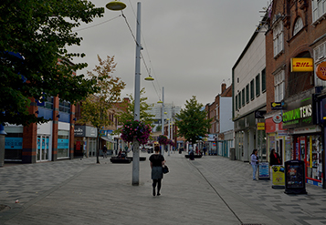 Rue de quartier bordée de boutiques et d'arbres