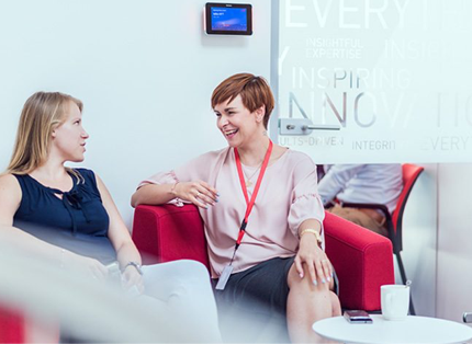 two young ADP associates seated and talking with one another