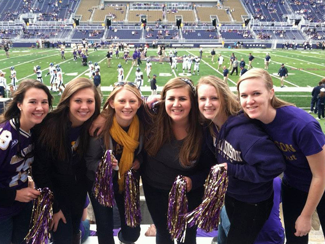 Emily A poses with her college roommates at a football game